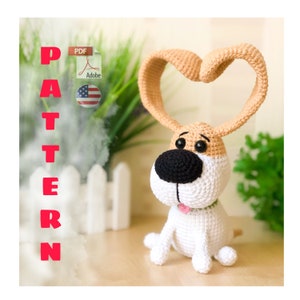 May include: Crochet pattern for a cute dog amigurumi toy. The dog is sitting with its ears in a heart shape. The pattern is available as a PDF download.
