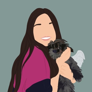 May include: A woman with long brown hair is smiling and holding a small black dog with white angel wings. The dog is looking at the camera.