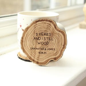 2 posavasos de madera para parejas con el texto "5 años y sigo siendo madera" para el quinto aniversario. Regalo personalizado para el quinto aniversario de bodas.