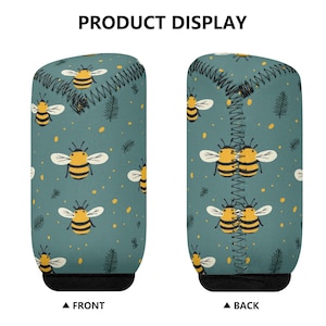 May include: Two cylindrical beverage insulators with a teal background and a pattern of yellow and black bees and small green leaves. The front and back of the insulators are displayed. The text "PRODUCT DISPLAY" is at the top.
