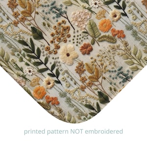 Op de afbeelding: Een bedrukt stoffen ontwerp met een herhalend patroon van verschillende bloemen en bladeren in tinten groen, bruin en oranje. De achtergrond is licht beige. De tekst "gedrukt patroon NIET geborduurd" is zichtbaar onderaan de afbeelding.