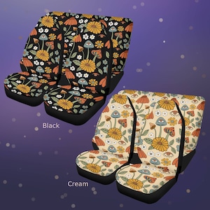 May include: Two sets of car seat covers, one with a black background and one with a cream background. Both feature a repeating pattern of yellow flowers, orange mushrooms, blue mushrooms with eyes, and small white flowers. The text Black and Cream is visible.