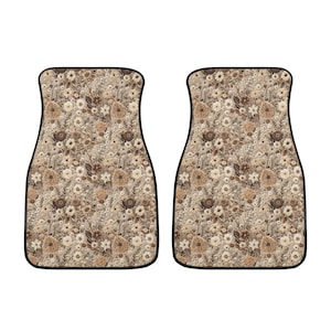 May include: A set of two car floor mats with a floral pattern in shades of brown and beige. The mats have a black border.