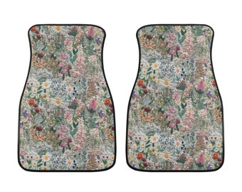 May include: A set of two car floor mats with a floral embroidery design. The mats are black with a white background and feature a variety of colorful flowers.