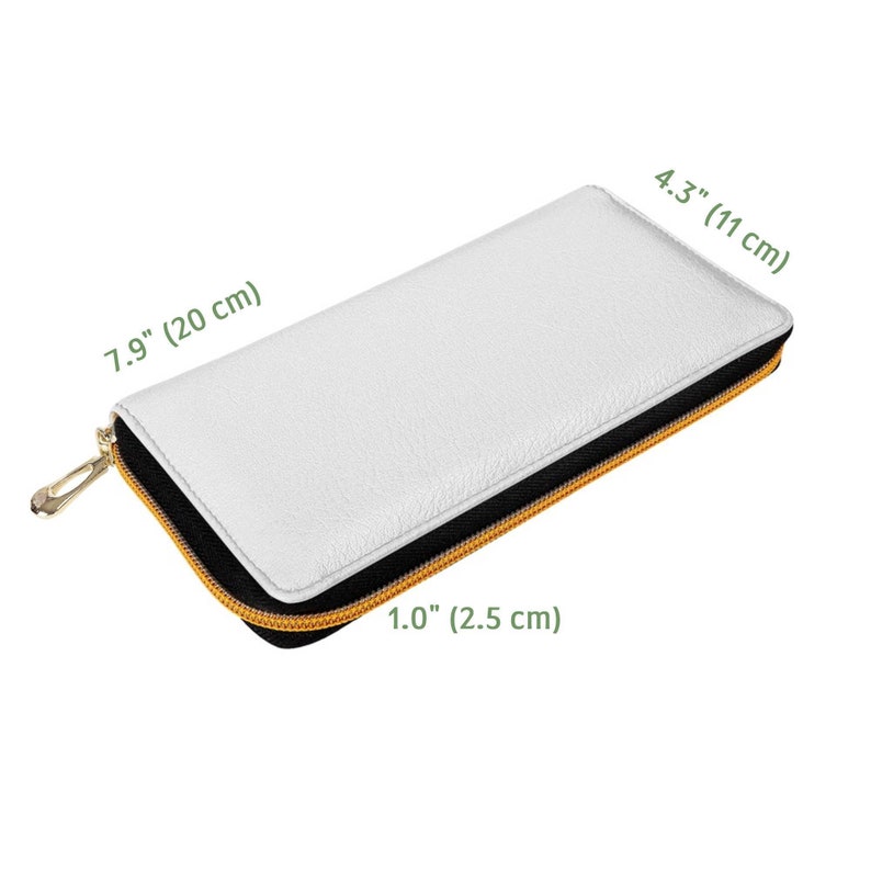 Puede incluir: Una cartera de cuero blanco con cremallera negra y tirador de cremallera dorado. La cartera mide 20 cm por 11 cm por 2,5 cm.