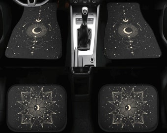 May include: A set of four black car floor mats with a celestial design featuring a crescent moon, stars, and geometric shapes in a gold color.