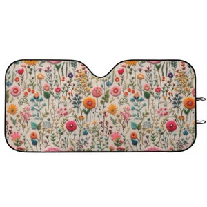 May include: A white car sunshade with a colorful floral embroidery pattern. The embroidery features various flowers, leaves, and stems in shades of pink, orange, yellow, green, and blue.