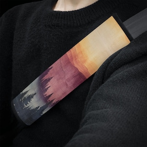 Könnte beinhalten: Eine farbenfrohe Sonnenuntergangsszene mit einer Silhouette von Bäumen im Vordergrund. Das Bild ist auf einen Stoffbezug für Auto-Sicherheitsgurte gedruckt.