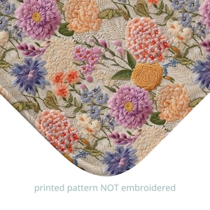 May include: A floral pattern featuring a variety of flowers in shades of pink, purple, orange, and yellow. The flowers are arranged in a random pattern on a white background. The text "printed pattern NOT embroidered" is printed at the bottom of the image.