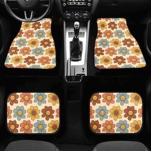 May include: Set of four car floor mats with a retro floral pattern featuring smiling yellow, orange, and blue flowers on a beige background.