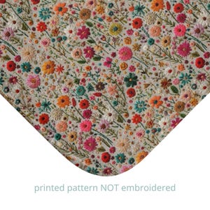 Könnte beinhalten: Nahaufnahme eines Stoffes mit einem gedruckten Muster aus bunten Blumen auf hellem beigefarbenem Hintergrund. Der Text "printed pattern NOT embroidered" ist unten im Bild gedruckt.