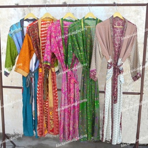 May include: Six colorful silk robes hanging on a rack. The robes are made of different fabrics and have various patterns, including floral, geometric, and patchwork designs. The robes are all in various shades of pink, green, blue, orange, and white.