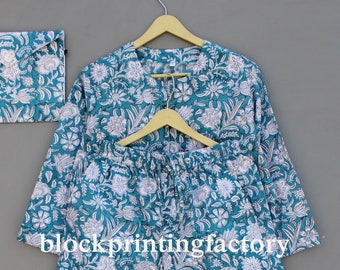 May include: A teal blue pajama set with a white floral pattern. The set includes a long-sleeved top and pants. The pants have an elastic waistband and a drawstring.