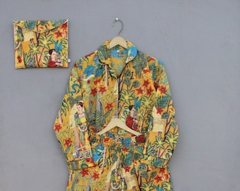 May include: A yellow pajama set with a floral print featuring a repeating pattern of people and plants. The set includes a long-sleeved shirt with a button-up collar and matching pants.