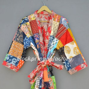 May include: A colorful patchwork quilted robe with a floral print. The robe has a tie belt and long sleeves.