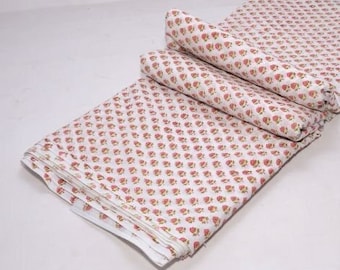 May include: White cotton fabric with a pink floral print. The fabric is folded in thirds and is ready to be used for sewing or quilting projects.