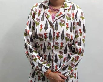 Könnte beinhalten: Weißes Pyjama-Set mit einem Blumen- und Blättermuster in Rot, Grün und Schwarz. Das langärmlige Oberteil hat einen Kragen und rote Paspeln. Die passende Hose vervollständigt das Schlafanzug-Ensemble.