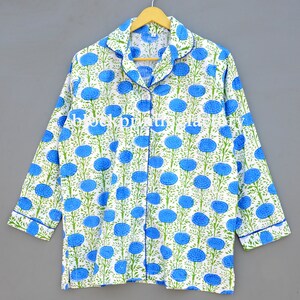 May include: A white cotton pajama top with a blue and green floral print. The top has a button-up front and long sleeves.
