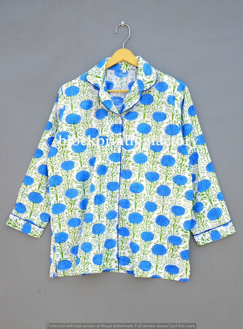 May include: A white cotton pajama top with a blue and green floral print. The top has a button-up front and long sleeves.