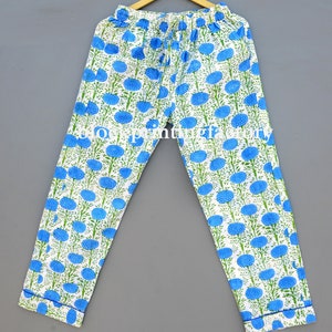 May include: White cotton pants with a blue floral print. The pants have an elastic waistband and a drawstring.