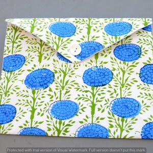 May include: A white envelope with a blue and green floral pattern. The envelope has a button closure and a black strap.