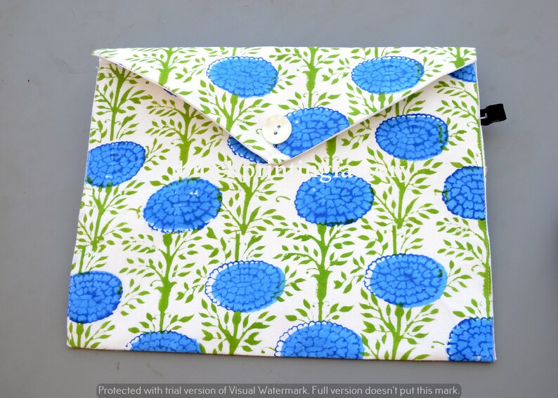 May include: A white envelope with a blue and green floral pattern. The envelope has a button closure and a black strap.