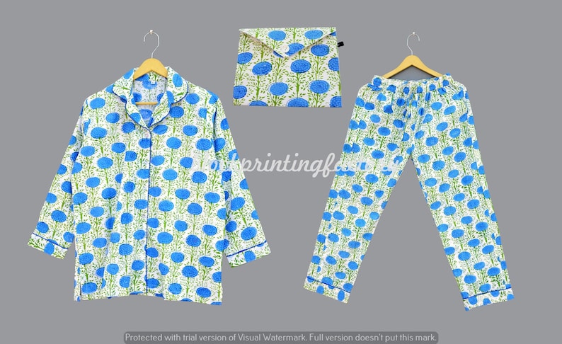 May include: A white pajama set with a blue floral pattern. The set includes a long-sleeved shirt with a collar and a pair of pants.