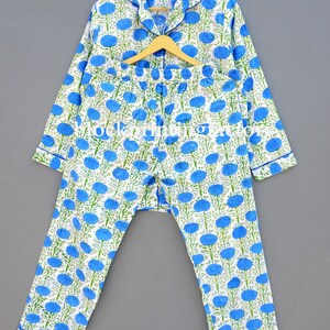 May include: A white pajama set with a blue floral print. The top has long sleeves and a button-up collar. The pants have an elastic waistband.