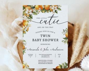 May include: A white baby shower invitation with a floral design featuring orange blossoms and leaves. The text reads "Two Little Cutie Are On The Way. Please Join Us For A Twin Baby Shower Honoring Amanda & John Andreson. Saturday August 24. The Caroline Residence 12345 Happy Way Los Angeles CA From 2-3 PM. RSVP By June 10 To Mom Call Or Text 123-456-7890 Registered At Amazon."