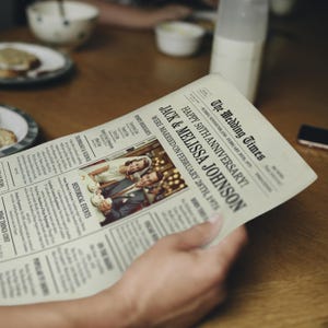 May include: A vintage newspaper style print with the headline "Happy 50th Anniversary! Jack & Melissa Johnson Were Married on February 28th, 1978". A photo of a couple in their wedding attire is featured in the center of the print.