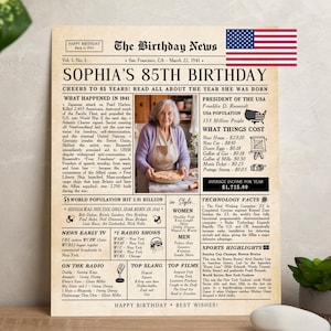 May include: A vintage-style newspaper poster titled The Birthday News for Sophia's 85th Birthday, dated March 22, 1941. It features a central photograph of a person holding a pie, historical facts, US flag icon, and columns detailing 1941 events.