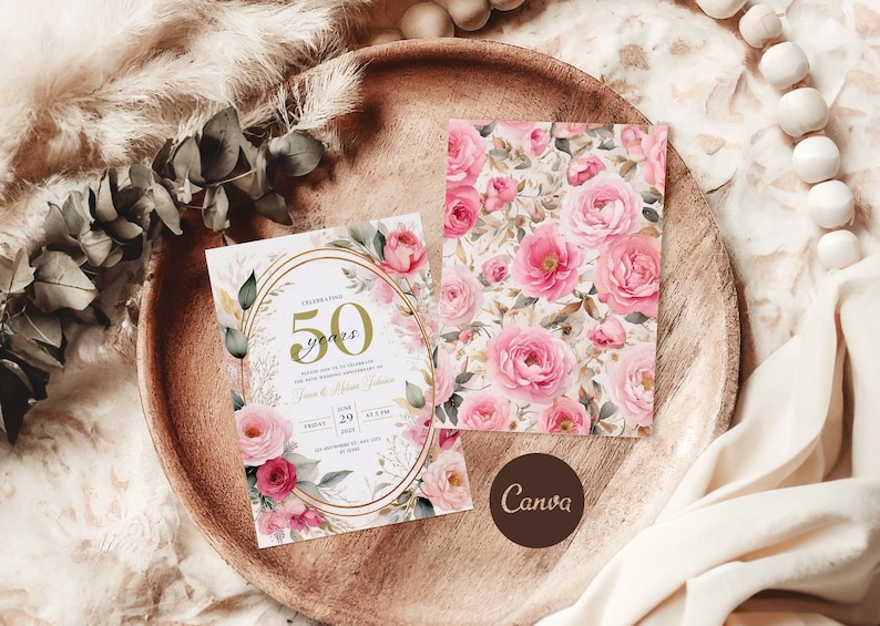 May include: A white invitation card with gold accents and a floral design. The card features the text "Celebrating 50 years" and a floral pattern with pink roses. The card is on a wooden surface with a white fabric background.