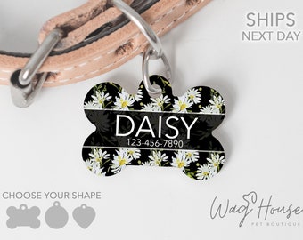 Könnte beinhalten: Schwarzes und weißes Hundehalsband mit einem Gänseblümchenmuster und dem Namen "Daisy" und der Telefonnummer "123-456-7890".