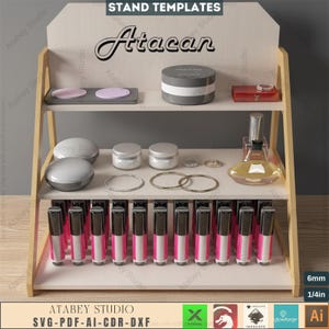 May include: A wooden display stand with multiple shelves, holding various cosmetic products. The stand features the text "STAND TEMPLATES" and "Atacan". Products include lipsticks, jars, compacts, and perfume bottles. The stand is designed to showcase beauty products.