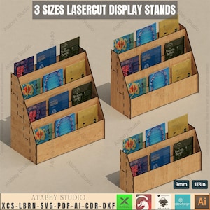 May include: Three sizes of laser-cut display stands made of wood. The stands are designed to hold books or other items. The stands are shown with books on them. The text "3 SIZES LASERCUT DISPLAY STANDS" is at the top of the image. The text "ATABEY STUDIO" is at the bottom of the image. The text "XCS-LBRN-SVG-PDF-AI-CDR-DXF" is at the bottom of the image. The text "3mm 1/8in" is at the bottom of the image.