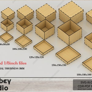 May include: A collection of laser-cut wooden boxes and trays in various sizes. The boxes have lids, while the trays are open. The text "Added 1/8inch files" and "MATERIAL THICKNESS 3MM" is visible. The dimensions are listed in millimeters.
