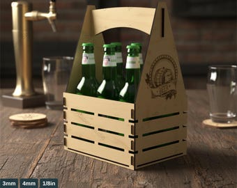 Puede incluir: Una plantilla de caja de madera para botellas de refresco-cerveza con asa, que contiene seis botellas de vidrio verde. La caja tiene un diseño cortado con láser y un gráfico con temática de cerveza. El texto "SODA-BEER BOTTLE BOX TEMPLATE" está en la parte superior.