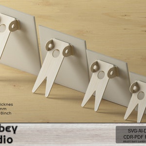 May include: Four wooden display stands with easel backs, each holding a light-coloured rectangular panel. The stands are made of light-coloured wood and are arranged in descending size. The text "Atabey studio" is visible.