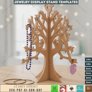 May include: A wooden jewelry display stand in the shape of a tree, with branches designed to hold necklaces, rings, and earrings. The stand is light brown and features cut-out bird and leaf designs. The text "JEWELRY DISPLAY STAND TEMPLATES" is at the top.