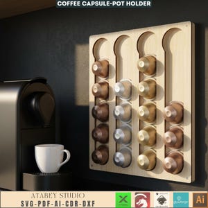 Puede incluir: Un soporte de c&aacute;psulas de caf&eacute; de madera clara, que contiene varias c&aacute;psulas de caf&eacute;. El soporte est&aacute; montado en la pared junto a una m&aacute;quina de espresso negra y una taza de caf&eacute; blanca. El texto "COFFEE CAPSULE-POT HOLDER" est&aacute; en la parte superior.