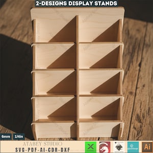 Puede incluir: Un expositor de madera con m&uacute;ltiples compartimentos. El expositor est&aacute; hecho de madera de color claro y presenta un dise&ntilde;o en niveles con varios estantes. El texto "2-DESIGNS DISPLAY STANDS" est&aacute; en la parte superior. El expositor tiene 6 mm (1/4 pulg) de grosor y tiene el texto "ATABEY STUDIO SVG-PDF-AI-CDR-DXF".