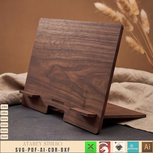 Può includere: Un leggio in legno marrone scuro con pannello posteriore inclinato e due piccoli supporti frontali. Il testo a sinistra elenca 1/4in, 1/8in, 6mm, 5mm, 4mm e 3mm. Il testo in basso riporta ATABEY STUDIO SVG-PDF-AI-CDR-DXF con varie icone.
