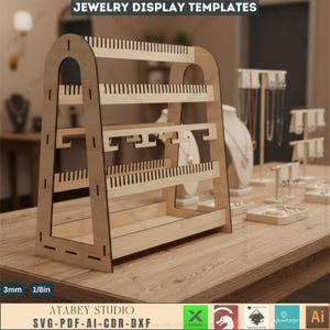 以下が含まれることがあります： イヤリング、ネックレス、その他のアクセサリーを展示するための、複数のレベルを備えた木製のジュエリーディスプレイスタンド。スタンドは明るい茶色で、さまざまなスロットとフックが付いています。「JEWELRY DISPLAY TEMPLATES」というテキストが上部にあります。幅20cm。
