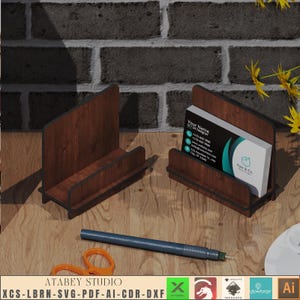 May include: A wooden business card holder with a dark brown wood grain finish. The holder has a slot for business cards and a raised base. The holder is sitting on a wooden surface. The text on the business card reads "Your Name UI/UX Designer".