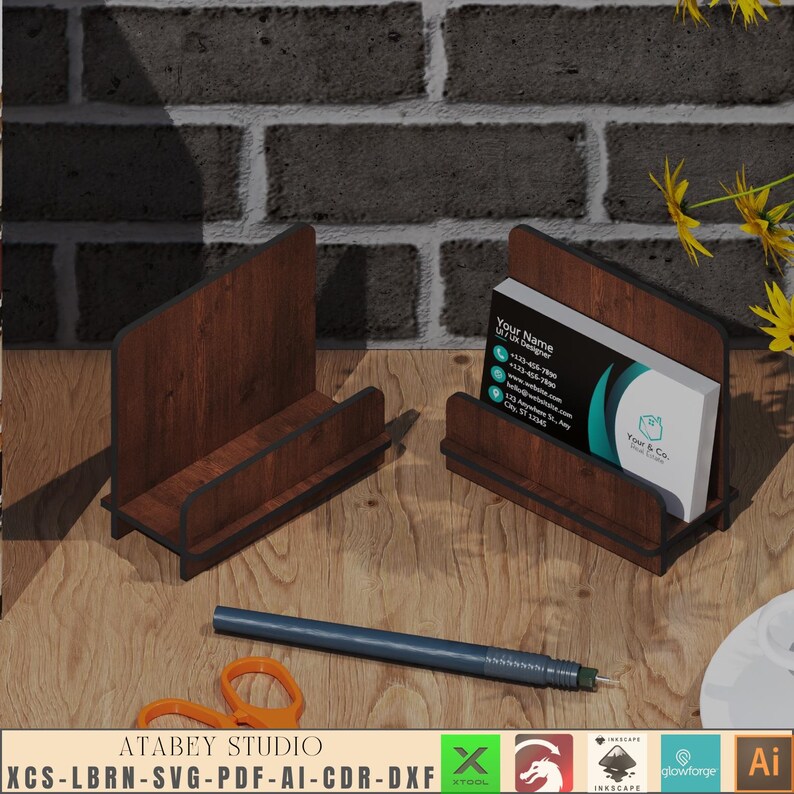 May include: A wooden business card holder with a dark brown wood grain finish. The holder has a slot for business cards and a raised base. The holder is sitting on a wooden surface. The text on the business card reads "Your Name UI/UX Designer".