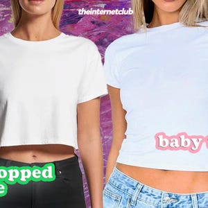 K&ouml;nnte beinhalten: Zwei Frauen tragen wei&szlig;e T-Shirts. Die Frau links tr&auml;gt ein bauchfreies T-Shirt mit dem Text "cropped tee" darunter. Die Frau rechts tr&auml;gt ein Baby-T-Shirt mit dem Text "baby tee" darunter.