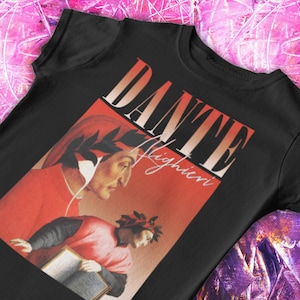 May include: Black t-shirt featuring a graphic print of Dante Alighieri, a renowned Italian poet. The graphic is in a retro style with a red and orange background.