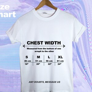 Op de afbeelding: Wit T-shirt met een zwarte maattabel voor de borstbreedte. De tabel toont de maten in inches en centimeters voor de maten S, M, L en XL. De tekst "CHEST WIDTH" en "ANY DOUBTS, MESSAGE US" staat ook op het T-shirt gedrukt.
