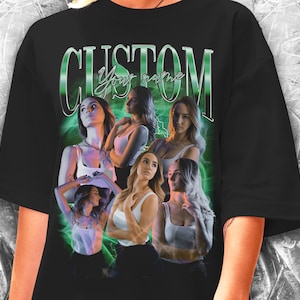 May include: Black oversized t-shirt with a graphic print of five women in front of a green and black lightning bolt design. The text "CUSTOM" is printed in large green letters with the text "Your name" printed in smaller white letters below.