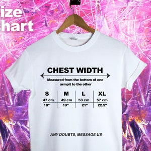 May include: White t-shirt with a size chart for chest width. The chart shows measurements in inches and centimeters for sizes S, M, L, and XL. The text "CHEST WIDTH" and "ANY DOUBTS, MESSAGE US" are printed on the shirt.